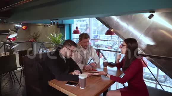 一个成年人在友好交谈后拥抱一个男人和一个女孩坐在咖啡馆里视频的预览图