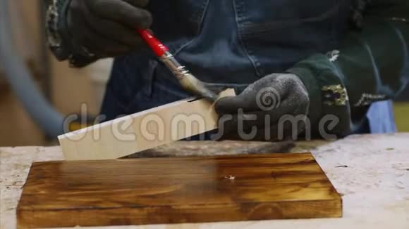 女性手的特写是在木板上涂上保护清漆视频的预览图