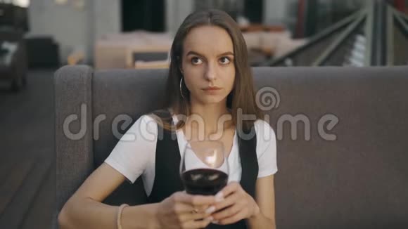 一个拿着一杯酒的单身女人抬头看着镜头绝望女孩视频的预览图