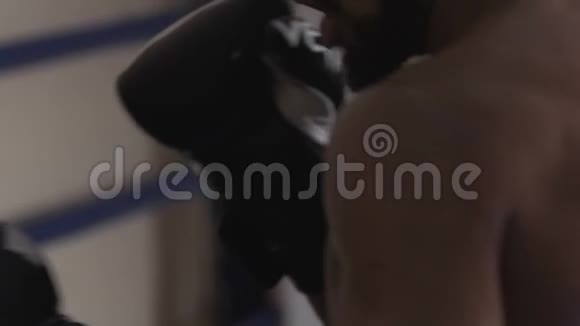 好斗的拳击手和他的私人教练在拳击场上用力挥肘视频的预览图