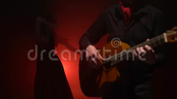 吉他手演奏弗拉门戈女孩跳舞从后面的光烟雾背景视频的预览图