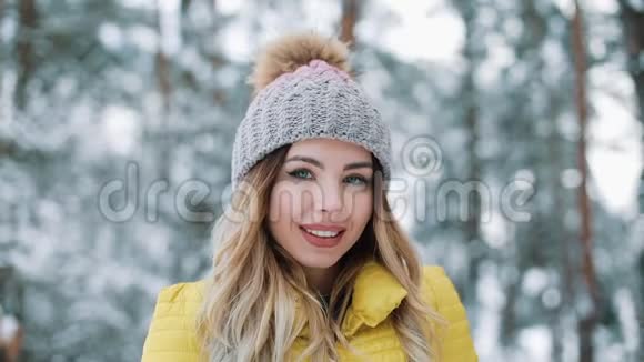 一位迷人的年轻女子看着镜头的冬天画像身穿黄色羽绒服的微笑女孩站在镜头前视频的预览图