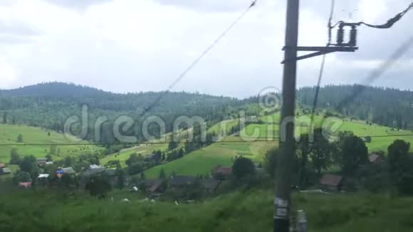 从一列火车的窗口到喀尔巴阡山的一个村庄的景色视频的预览图