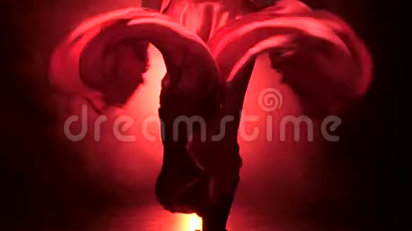 弗拉门戈舞者在音乐的节奏中发展裙子从后面发光烟雾背景关门视频的预览图