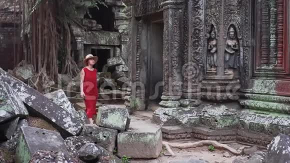 穿着红色衣服的白人妇女正在塔普罗姆废墟中行走视频的预览图