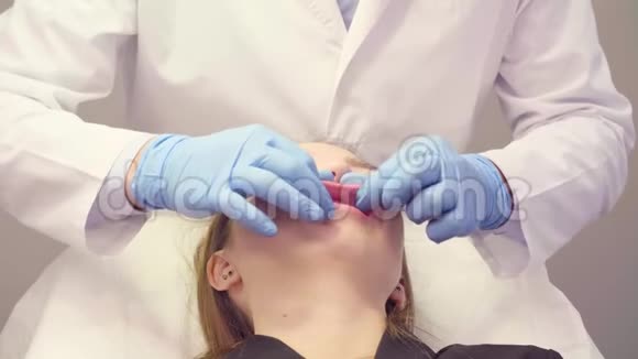 医生用手按摩病人嘴唇视频的预览图