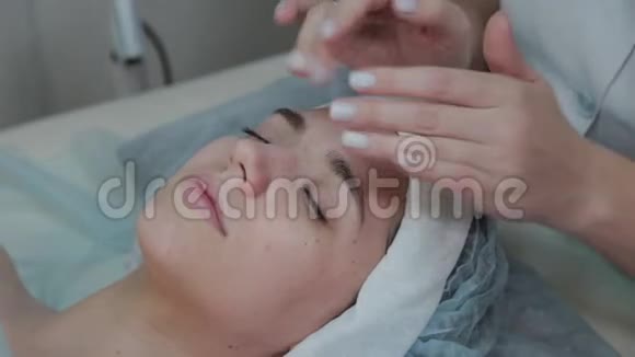 专业美容师女性对客户妇女进行面部按摩视频的预览图