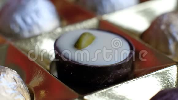 女人从盒式美味的甜点背景中选择各种巧克力宏观特写视频的预览图