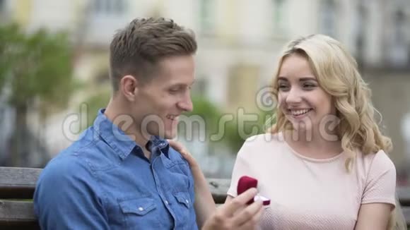 戴戒指的男人戴着女朋友的手指亲吻她订婚视频的预览图