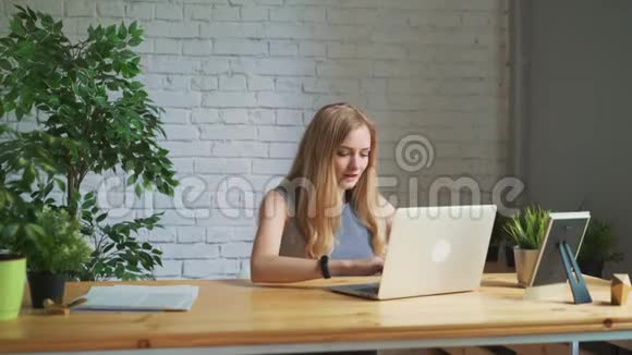 快乐的女人兴奋地看着坐在工作场所的笔记本电脑屏幕庆祝商业成功在获胜视频的预览图