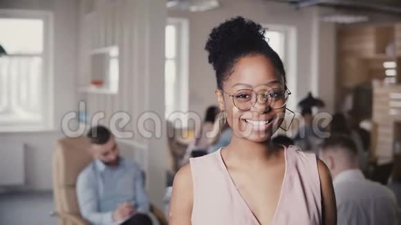 美丽的年轻非洲裔美国成功女商人的肖像在阁楼办公室背景4K看相机视频的预览图