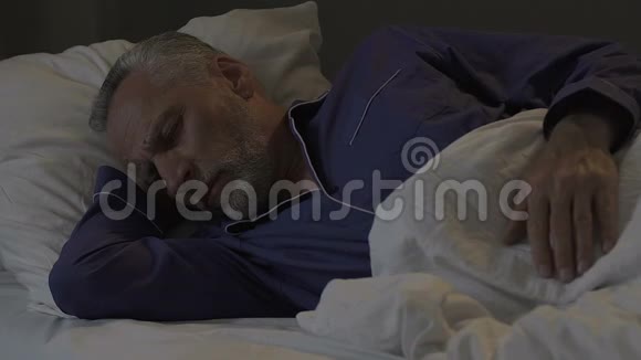 老人躺在床上睡在黑暗的房间里晚上恢复能量视频的预览图