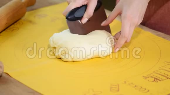 女面包师用面粉把生面团卷切成块视频的预览图