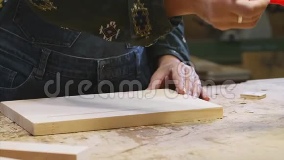 女性手的特写是在木板上涂上保护清漆视频的预览图