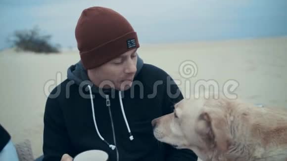 一个年轻人和他的狗在户外度假野餐时一个人当着狗面思考视频的预览图