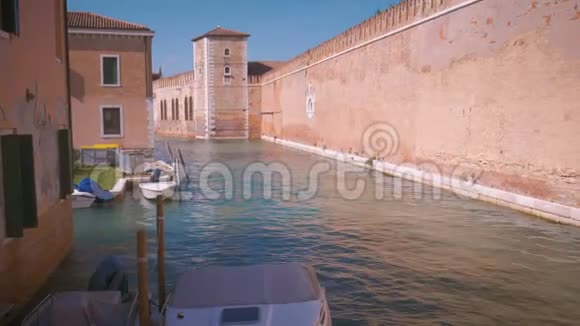 在威尼斯的一座小运河和一座砖墙上的景色视频的预览图