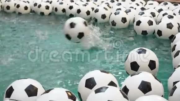 许多黑白足球背景足球球在纯净水中游泳一球落入水中视频的预览图