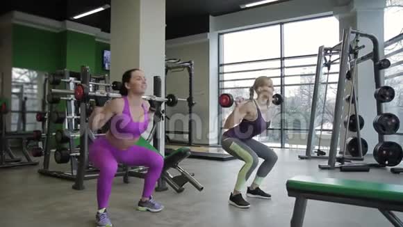 两个女朋友在现代健身房做背蹲视频的预览图