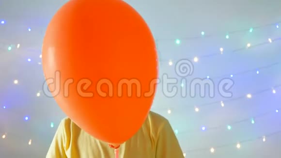 亚洲小女孩躲在气球后面在闪闪发光的背景下做一个迷你心脏手势视频的预览图