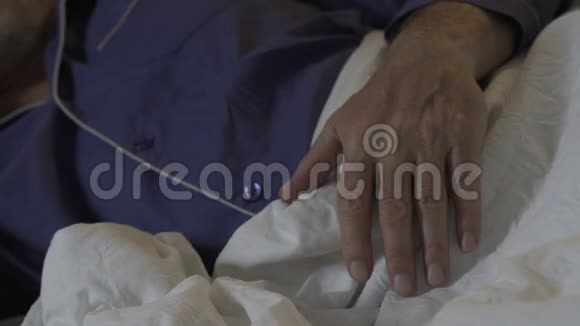 老人的手在晚上躺在毯子上睡得安稳休息视频的预览图