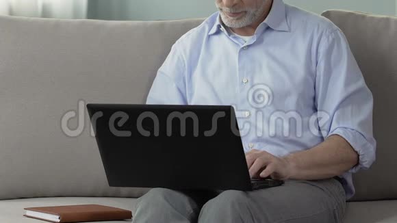 灰发男性使用笔记本电脑在线交流新娘搜索在线服务视频的预览图