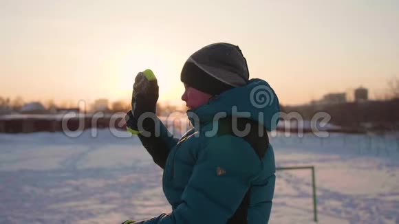冬公园里的一个少年微笑着挥手致意日落的时候在新鲜空气中游走健康的生活方式视频的预览图