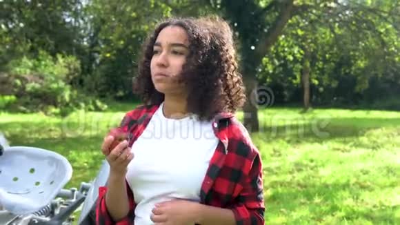 美国黑人混血少女少女在果园里用拖拉机吃苹果视频的预览图