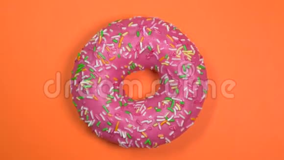 美味和新鲜的甜甜圈特写镜头旋转在橙色的背景视频的预览图