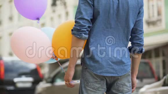 带着气球等着约会的人女孩靠近拥抱他见面视频的预览图
