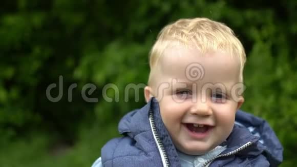 小男孩走在公园里对着镜头微笑视频的预览图