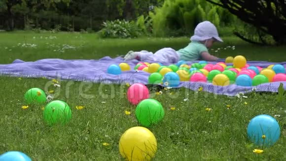 可爱的小女孩在草地上的格子花球之间玩得很开心4K视频的预览图