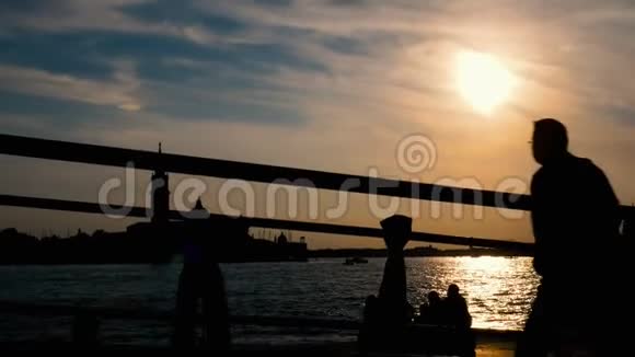 日落时分人们在威尼斯的运河景观中穿过大桥视频的预览图