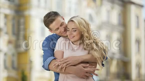 恋爱中的情侣拥抱亲吻男人从背后拥抱女孩温柔视频的预览图