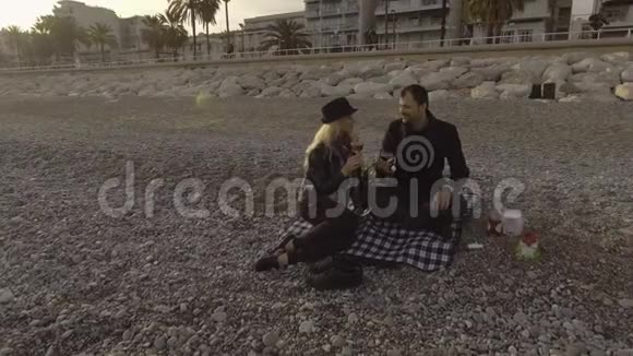 女性和男性在法国里维埃拉海滩上喝葡萄酒浪漫视频的预览图