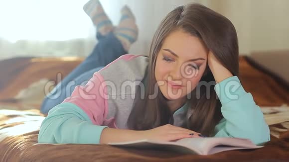 年轻漂亮的女人专心读书玩得很开心漂亮模特可爱的笑容布鲁内特蓝眼睛视频的预览图