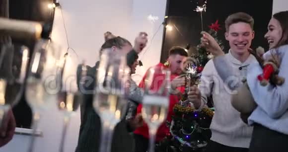 新年庆典当年轻人在圣诞节前在背景上跳舞时他会在杯子里倒香槟视频的预览图