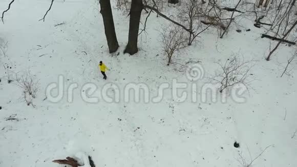 冬季森林中穿黄色外套用跳绳运动的运动员空中活动视频的预览图