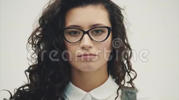 一位年轻漂亮的黑发商务女性的特写肖像嘴巴和眼睛用眼镜睁开视频的预览图