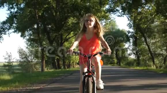 夏天骑自行车旅行时可爱的金发少女视频的预览图
