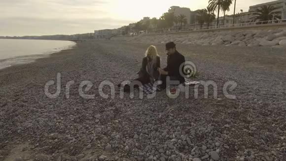 恋爱中的男人和女人在海边野餐开瓶红酒约会视频的预览图