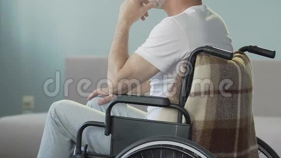 老人坐在轮椅上看着双腿点头失去了行走的能力视频的预览图