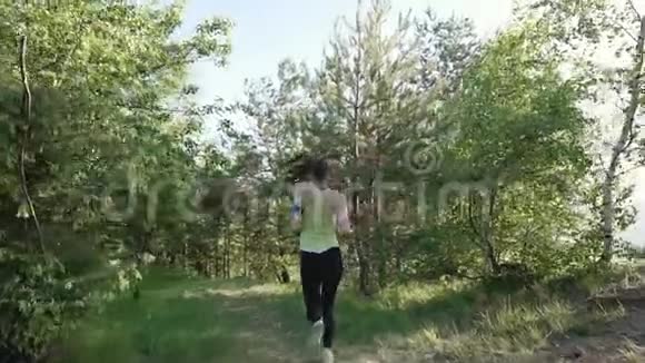 后景跑步青年妇女在公园跑步锻炼户外健身跟踪可穿戴技术女运动员视频的预览图