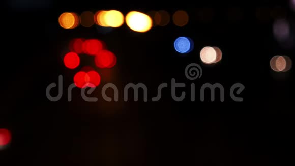 从城市街道上行驶的汽车的灯光上移动bokeh圆圈城市模糊背景夜间交通视频的预览图