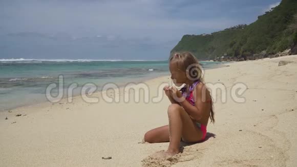 海滩上的小女孩带着棒棒糖视频的预览图