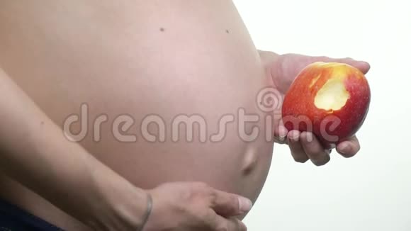 关心婴儿的健康孕妇的腹部和她手中的一个被咬的苹果视频的预览图