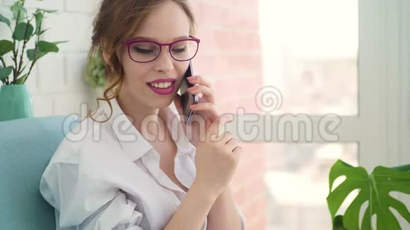 快乐的年轻女子在家卧室打电话给智能手机视频的预览图
