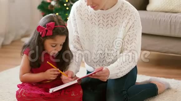 妈妈和女儿在圣诞节带笔记本视频的预览图