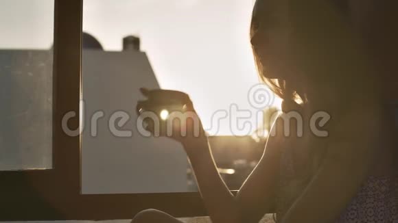日出时女人在窗台上喝咖啡视频的预览图
