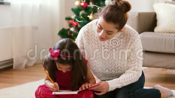 妈妈和女儿在圣诞节带笔记本视频的预览图