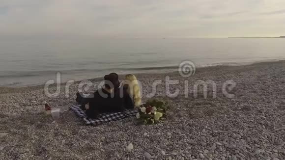 一对情侣躺在沙滩上聊天海浪拍打着海岸约会视频的预览图